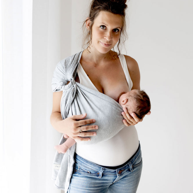 Mama stillt Kind in RingSling