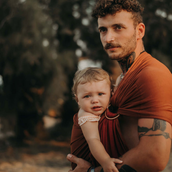 Vater mit Kind in Ring Sling